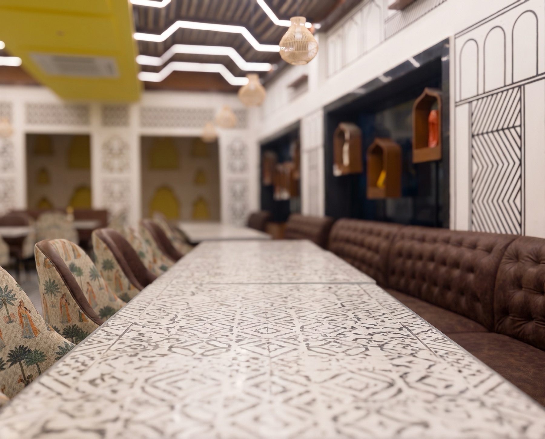 The dining room — printed tabletops, leather booths and rattan lights